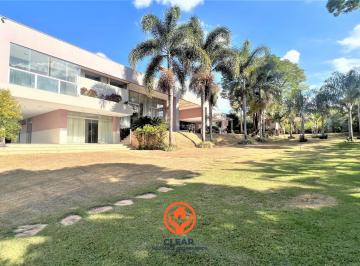Vista aérea da fachada moderna da Casa 608m² no Braúnas BH, com jardim amplo, palmeiras e terreno de 3.070m² totalmente plano. · Casa no Braúnas BH | 608 m², Terreno 3.070 m² e 10 Vagas
