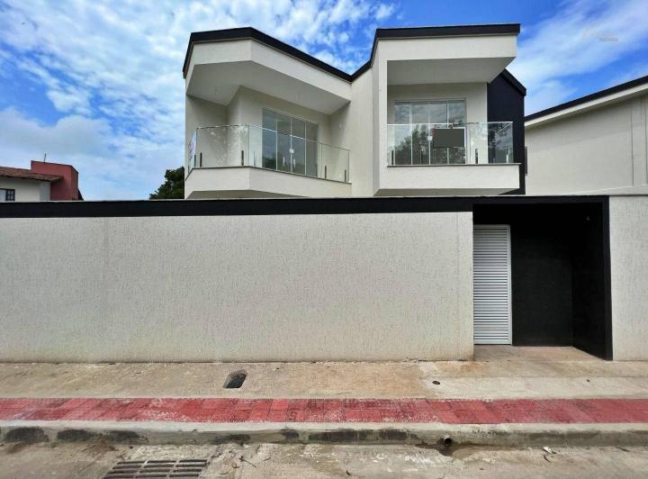 Fachada de casa de esquina preta e cinza com concreto e alumínio