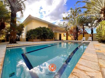Piscina ampla com área de lazer completa, destaque para o deck em pedra e paisagismo no Bairro Bandeirantes BH · Casa 420 m² no Bandeirantes BH | 5 Quartos, 6 Vagas e Lazer Completo