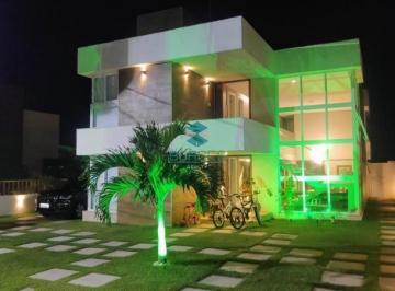 Fachada iluminada e paisagismo moderno | Borges Re · Casa duplex de alto padrão à venda no Condomínio Paraíso dos Lagos - Guarajuba, Camaçari: 5 suítes, 