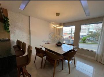 Sala de jantar moderna com mesa para 6 lugares, lustre contemporâneo e móveis planejados em conceito aberto. · Sobrado de Alto Padrão no Fazenda Velha | Araucária