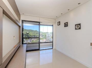 Living com painel de TV e porta para a sacada envidraçada · Apartamento 2 quartos 77,23m² Fazenda Itajaí