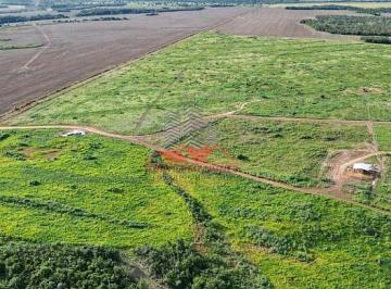 Vista aérea de drone mostrando a vasta extensão de uma fazenda plana em Santa Rita do Tocantins, com áreas de terra vermelha preparada para plantio ao lado de áreas verdes de pastagem. · Fazenda 682 ha em Santa Rita - TO | 4km da BR-153 | Plana
