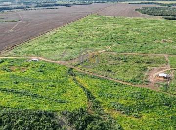 Vista aérea de drone mostrando a vasta extensão de uma fazenda plana em Santa Rita do Tocantins, com áreas de terra vermelha preparada para plantio ao lado de áreas verdes de pastagem. · Fazenda 682 ha em Santa Rita - TO | 4km da BR-153 | Plana