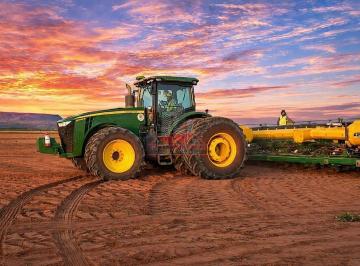 Trator verde de alta potência com plantadeira acoplada operando em vasta área de terra preparada na fazenda de 23 mil hectares no Maranhão. · Mega Fazenda no Maranhão: 23.167 ha com Safra e Safrinha