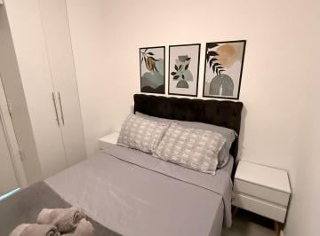 Quarto com cama, armário e mesas de cabiceira · Apartamento Amplo e Mobiliado e com vaga de garagem e área de lazer