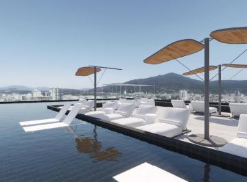 Piscina do rooftop com espreguiçadeiras e os morros ao fundo (imagem ilustrativa) · Apartamento 1 dormitório 47,71 m² no Metropolitan, Fazendinha, Itajaí