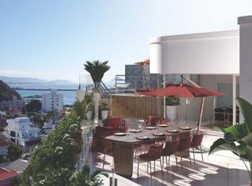 Terraço da cobertura de 291 m² com mesa de jantar e o mar ao fundo (imagem ilustrativa) · Cobertura duplex de 291 m² com piscina e vista para o mar, Itajaí