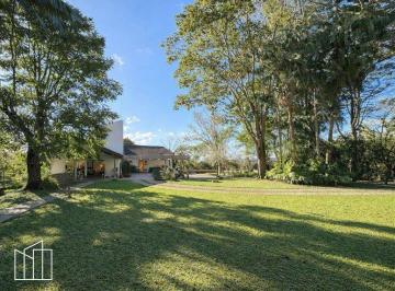 Jardim e fachada da casa térrea em terreno de 10.490 m², na Fazendinha, Granja Viana. · Casa na Fazendinha, Granja Viana, terreno de 10.490 m², térrea, chalé de hóspede