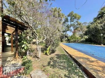 Varanda com vista para a piscina, na casa rústica no condomínio Vilarejo Vila Diva. · Casa rústica em condomínio, Vilarejo Vila Diva, 1.642 m², 3 dormitórios, 1 suíte