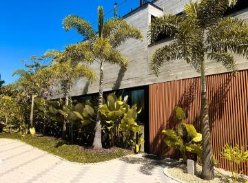 Casa em concreto aparente com palmeiras na entrada · Casa com 3 suítes e piscina privativa no AYA Casas, Praia do Estaleiro