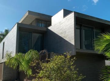 Volumes em concreto e vidro de uma das casas · Casa de 570 m² com 3 suítes em condomínio fechado na Praia do Estaleiro
